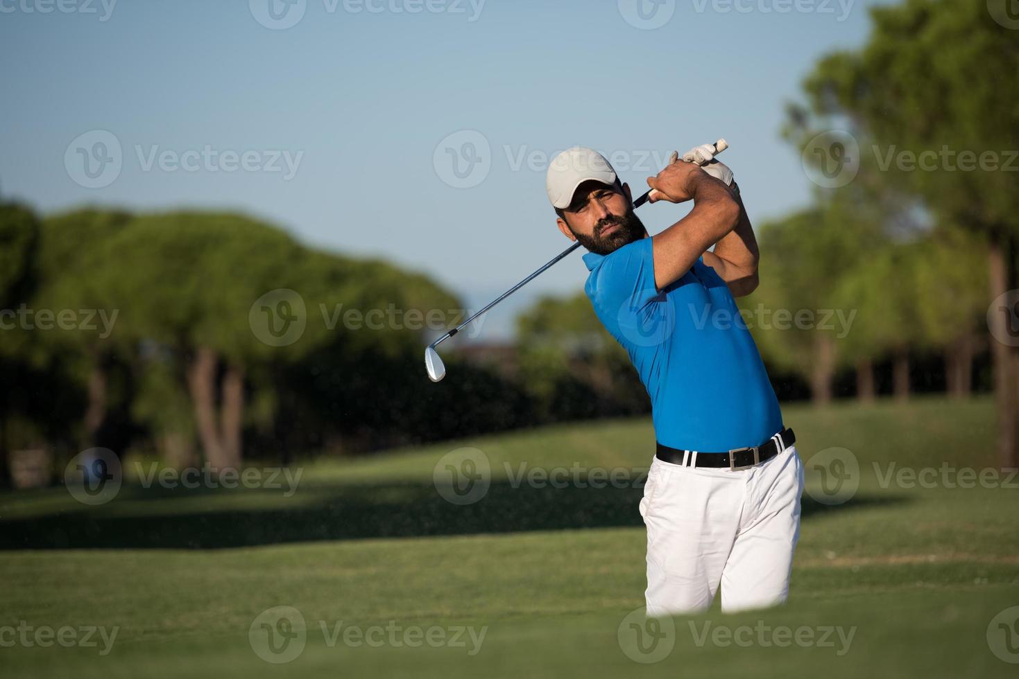 pro golfer hitting a sand bunker shot photo