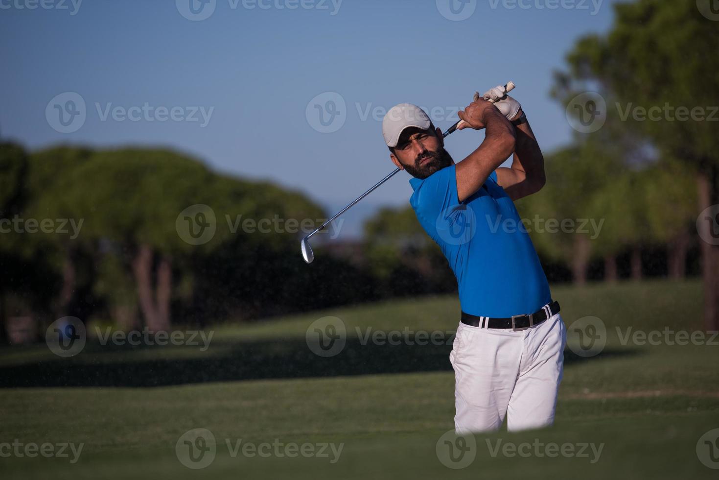 pro golfer hitting a sand bunker shot photo