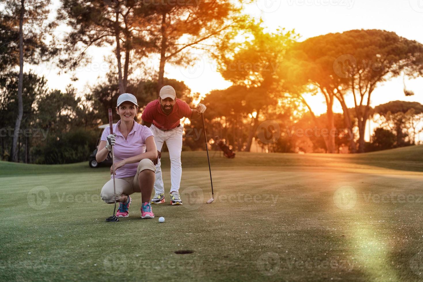 pareja en campo de golf al atardecer foto