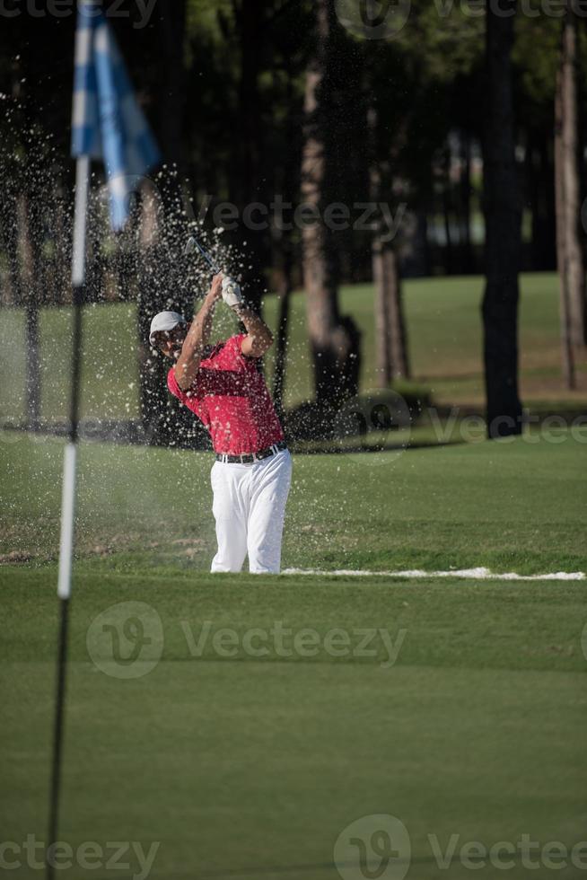 golfer hitting a sand bunker shot photo