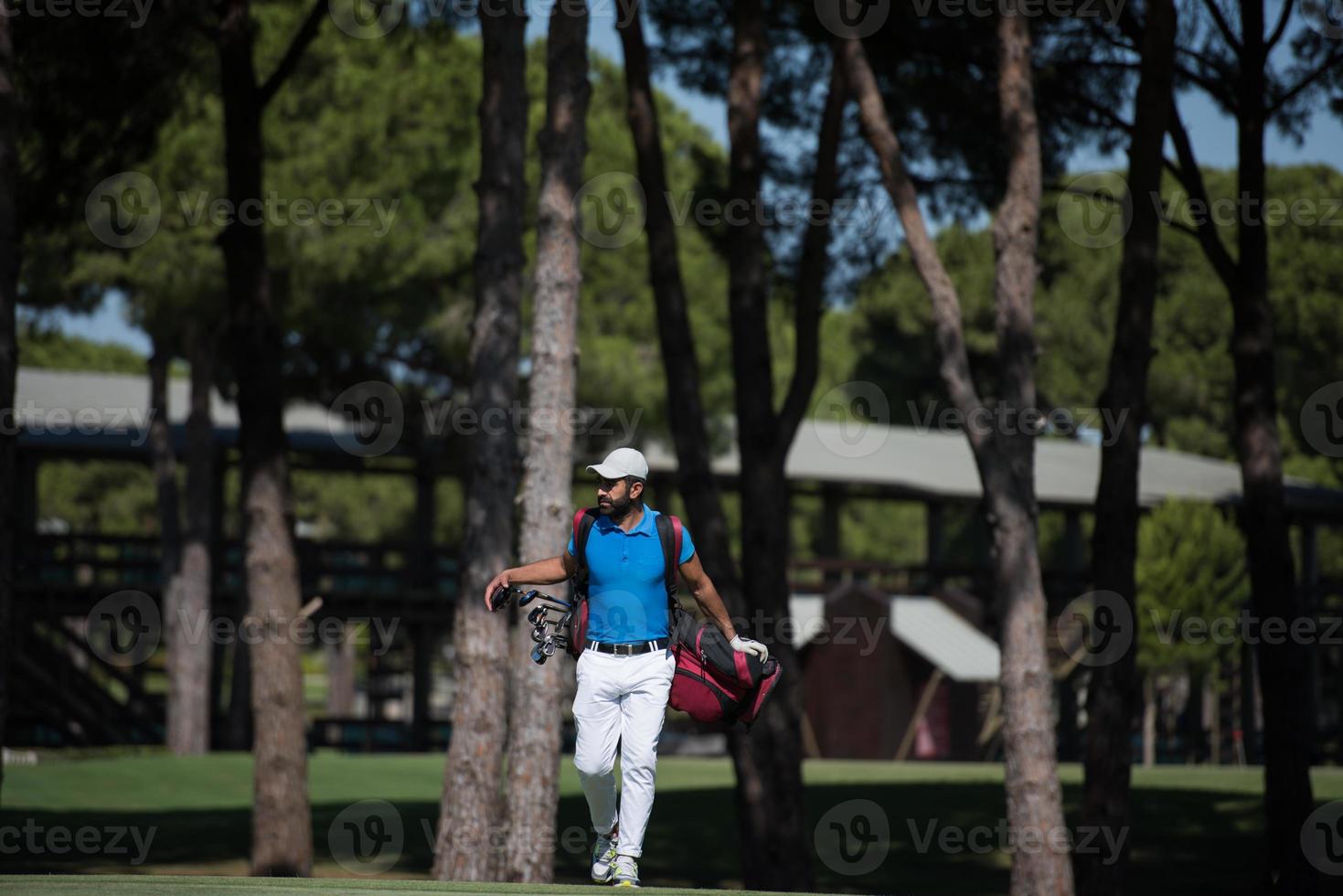 golf player walking and carrying bag photo