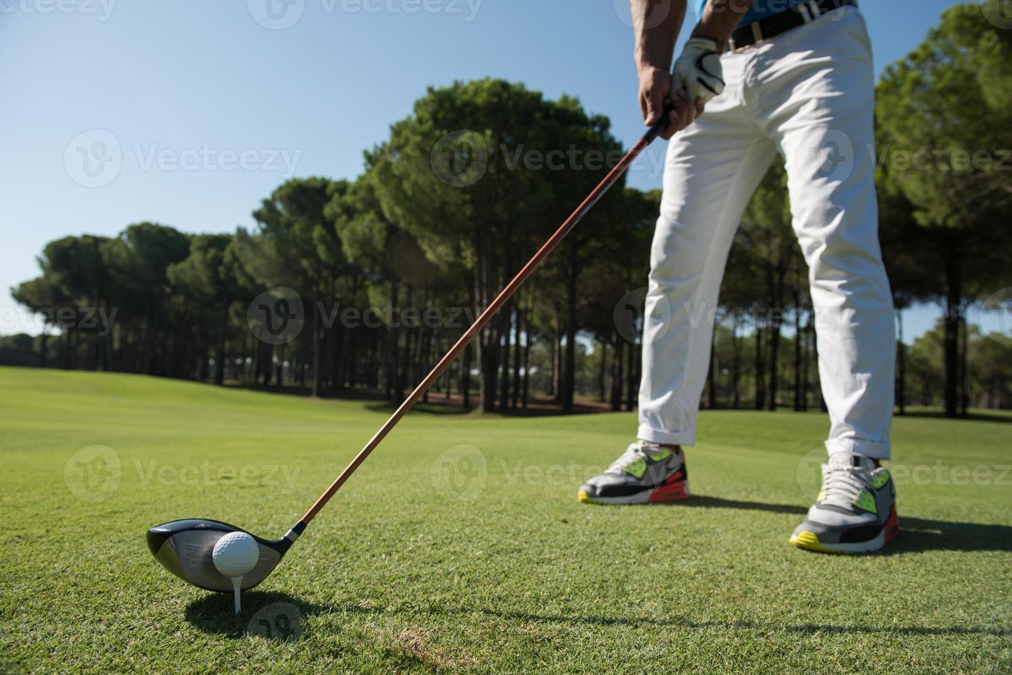 golf player placing ball on tee photo