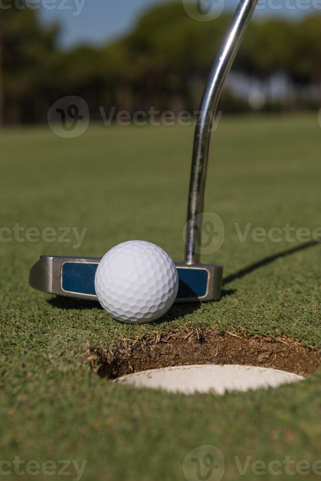 hitting golf ball to hole photo