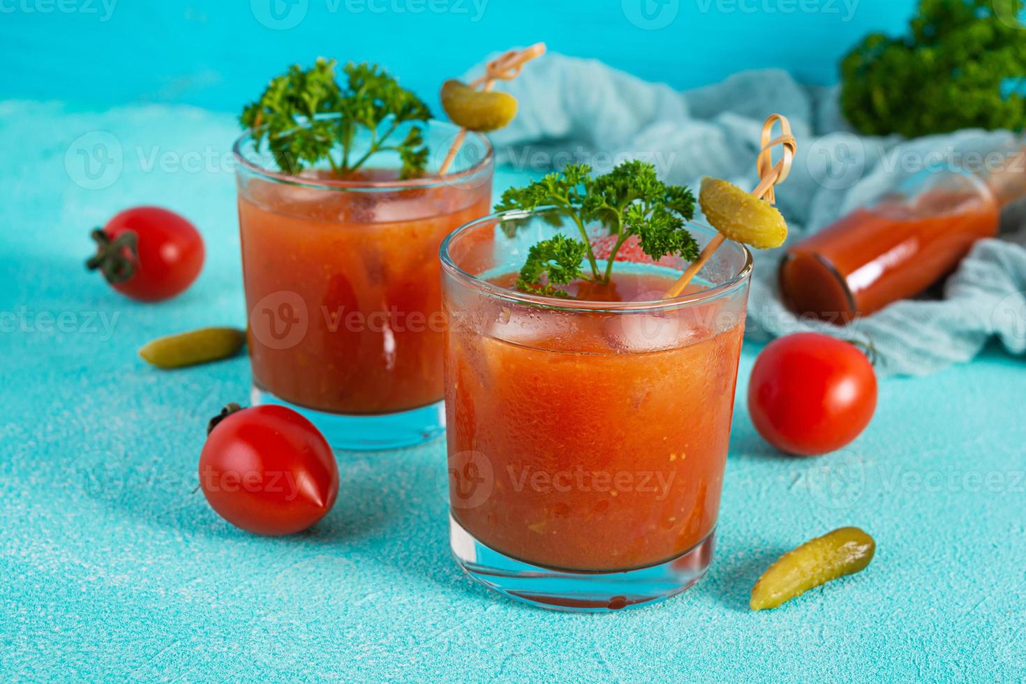 Alcohol cocktail Bloody Mary on blue background. Classic cocktail with tomato juice and vodka photo