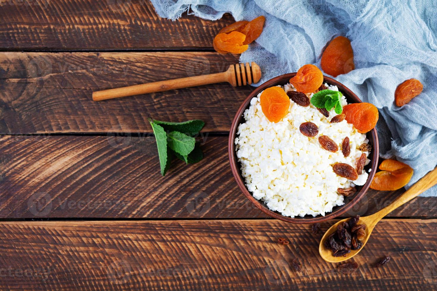 Healthy breakfast cottage cheese with raisins, dried apricots, almond, cashew and mint. Top view photo