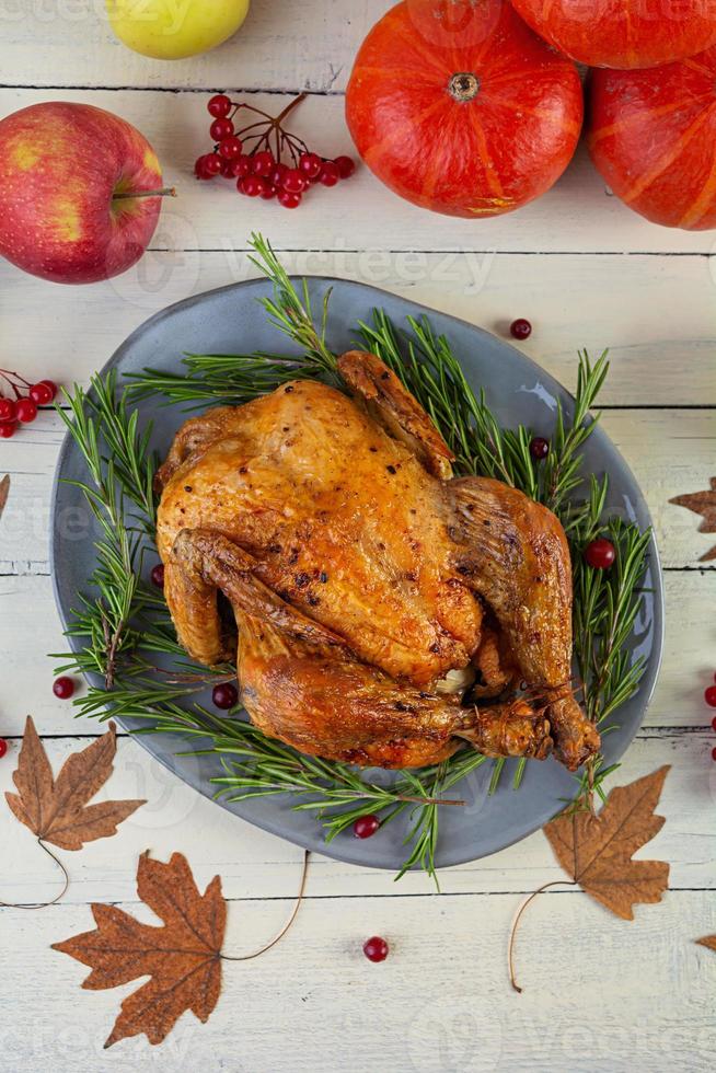 Baked whole chicken or turkey. Roasted homemade chicken with herbs. Thanksgiving day decoration. Top view photo