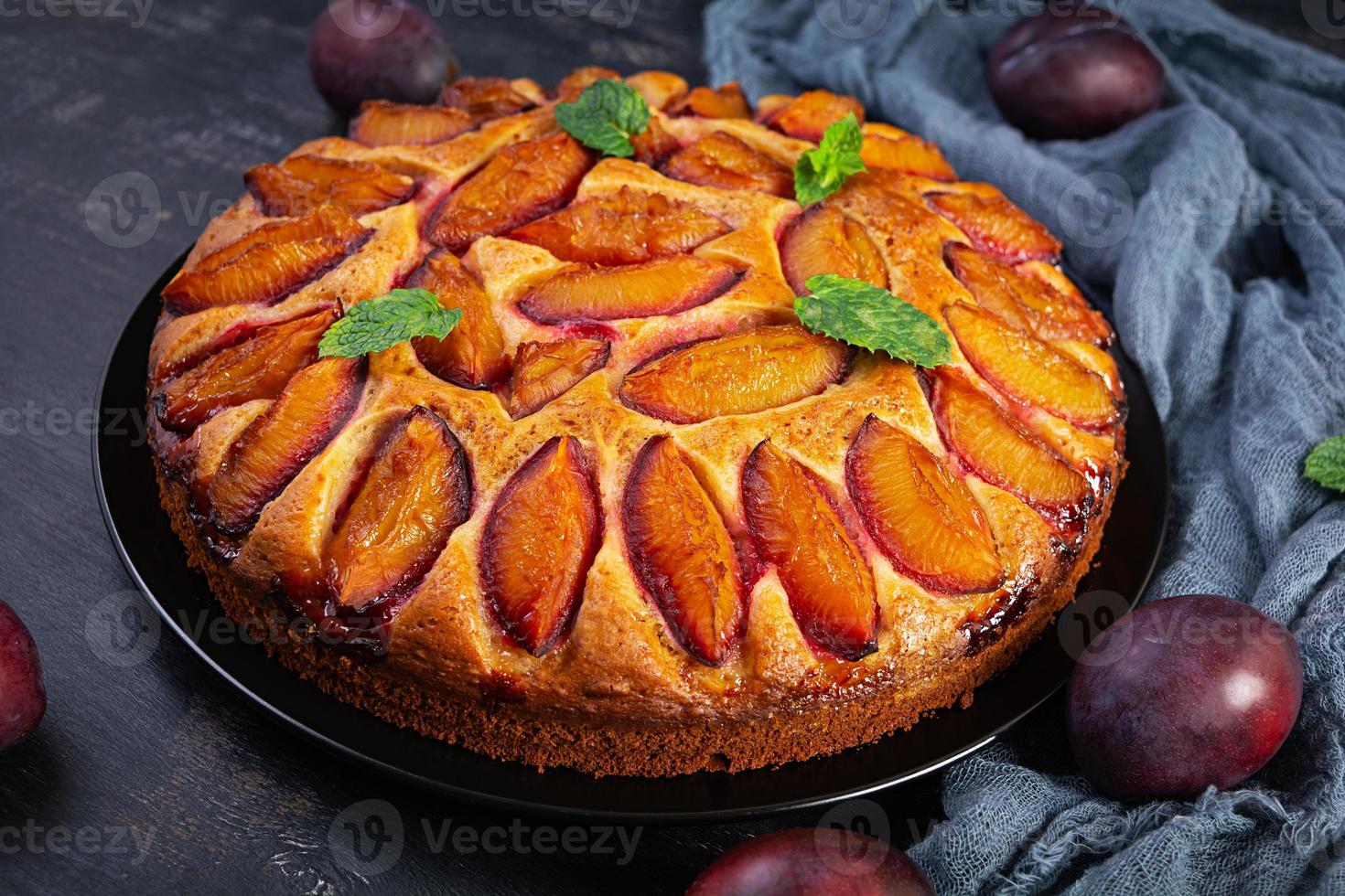 Delicious plum cake on wooden background. Homemade plum pie photo