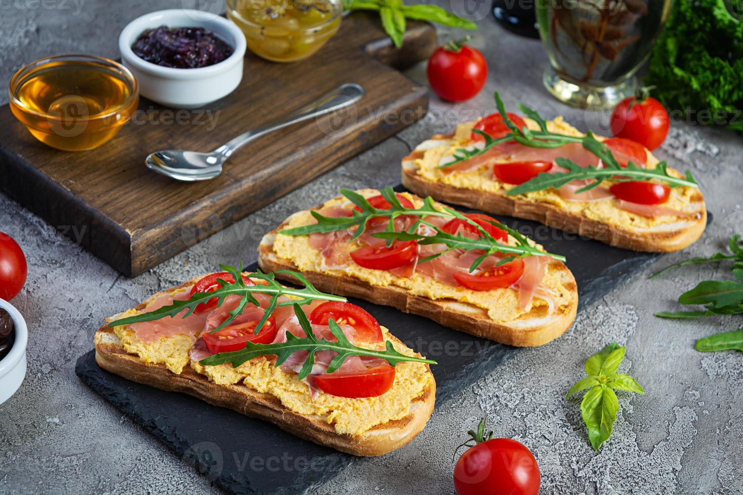 bruschetta a la parrilla con rillettes de pollo, jamón y hierbas. deliciosa tostada con paté de pollo y diferentes aperitivos foto