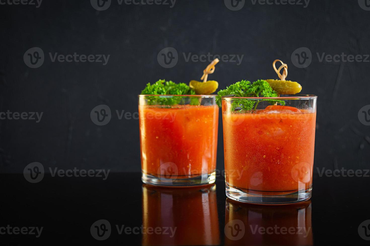 Alcohol cocktail Bloody Mary on dark background. Classic cocktail with tomato juice and vodka photo