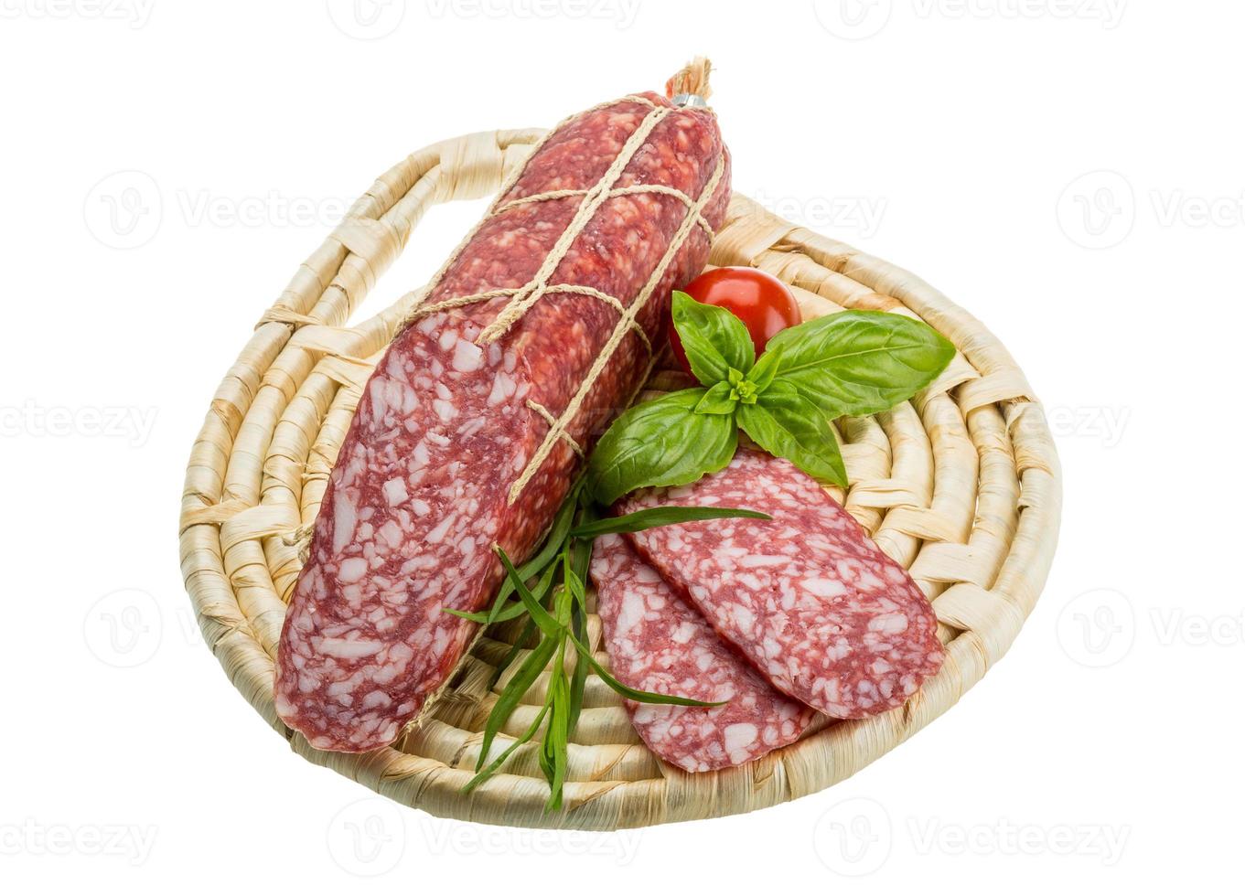 salami en placa de madera y fondo blanco. foto