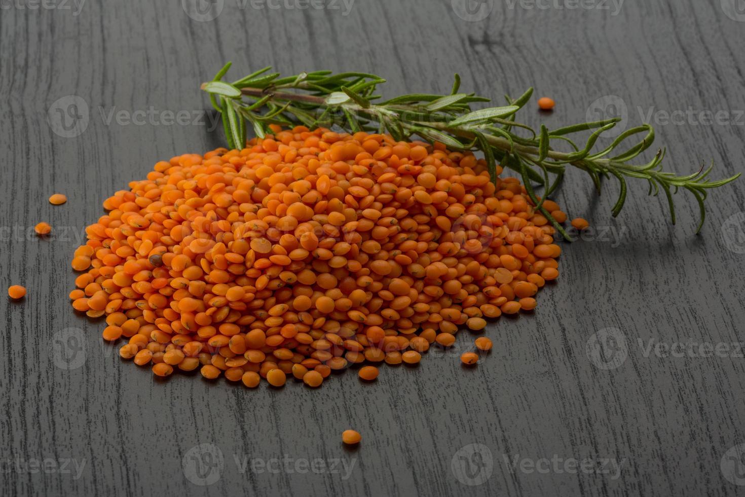 Red raw lentils on wooden background photo