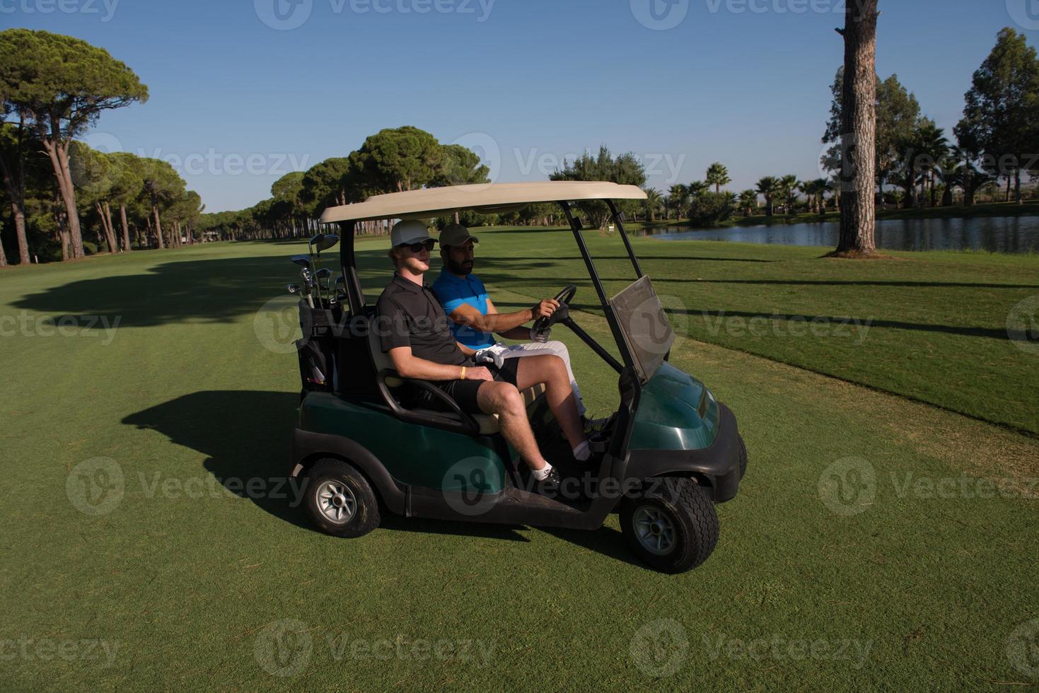 golf players driving cart at course photo