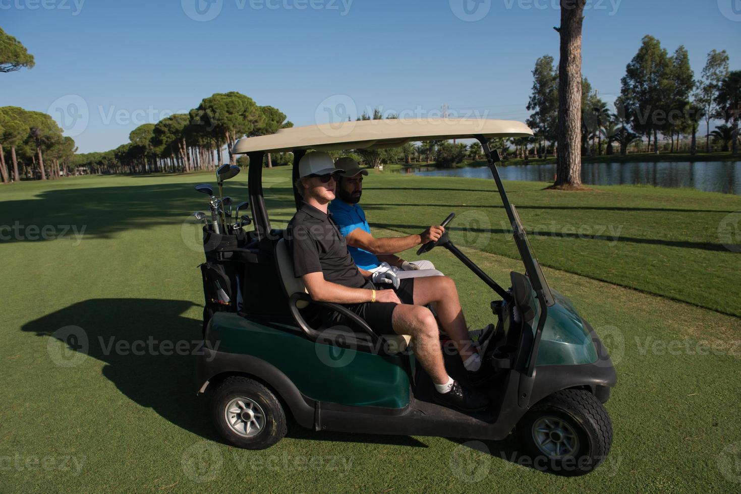 golf players driving cart at course photo