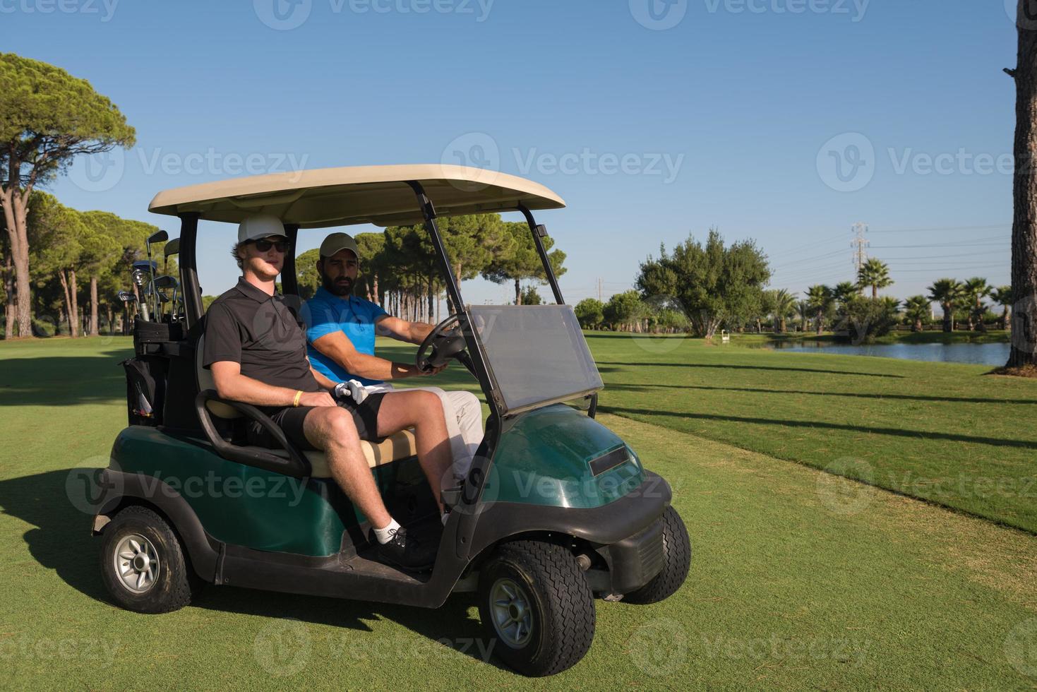 golf players driving cart at course photo