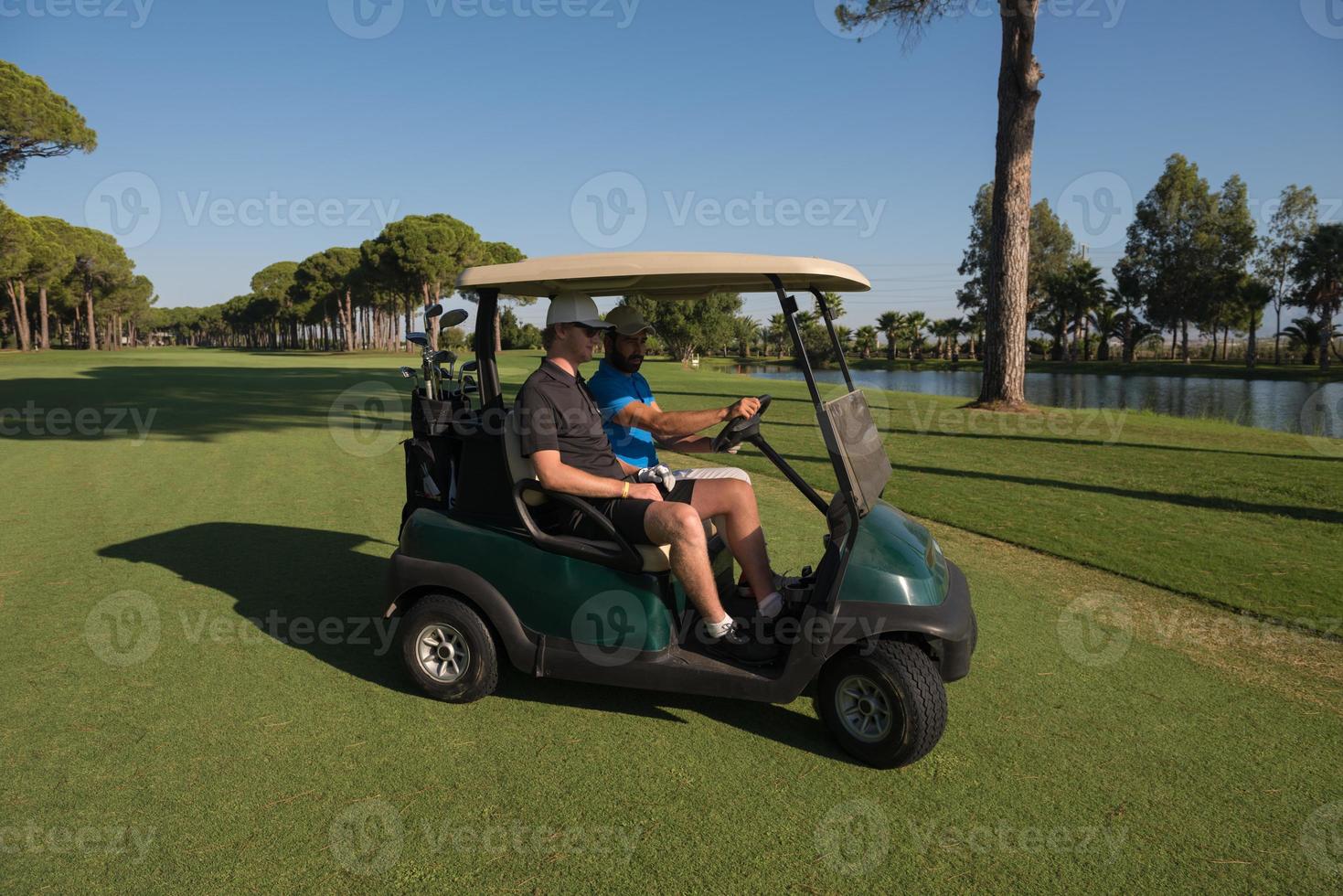 golf players driving cart at course photo