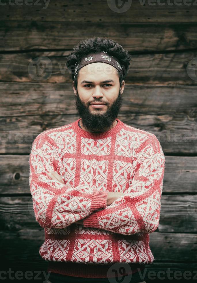 portrait of young hipster in front of wooden house photo