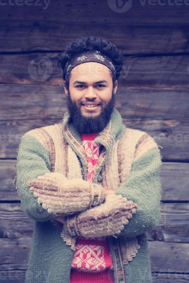 portrait of young hipster in front of wooden house photo