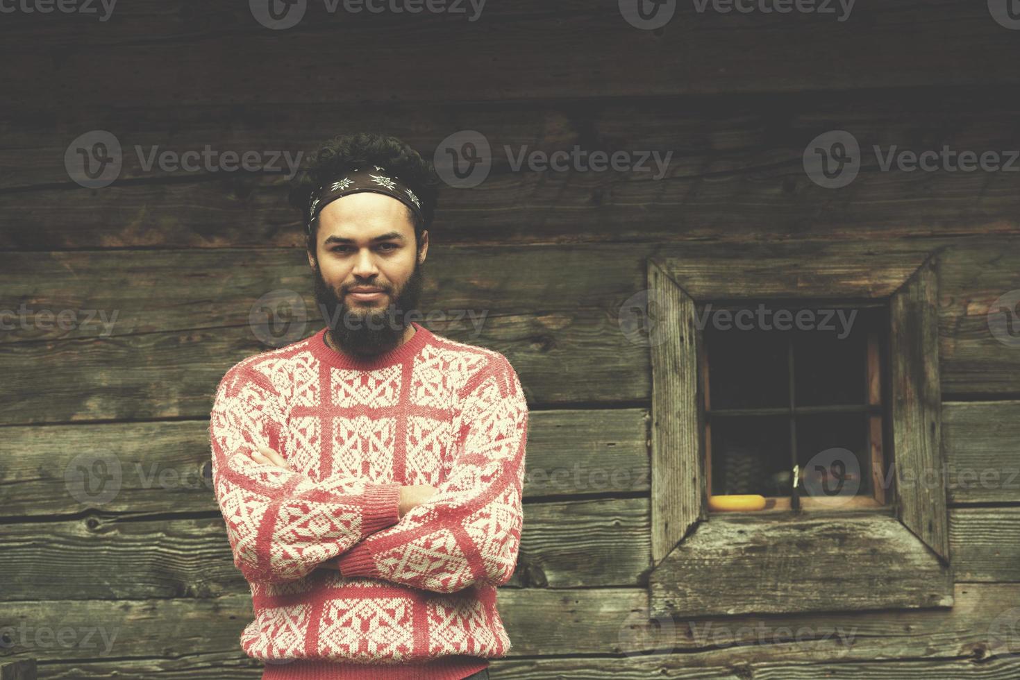 retrato de joven hipster frente a casa de madera foto