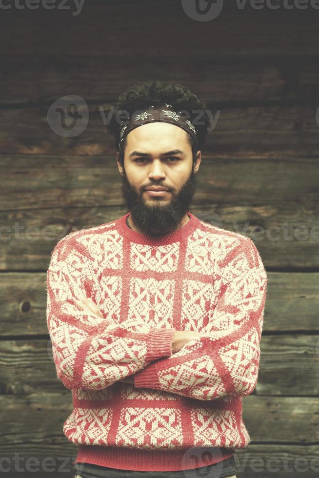 portrait of young hipster in front of wooden house photo