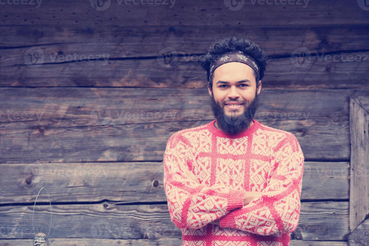 portrait of young hipster in front of wooden house photo