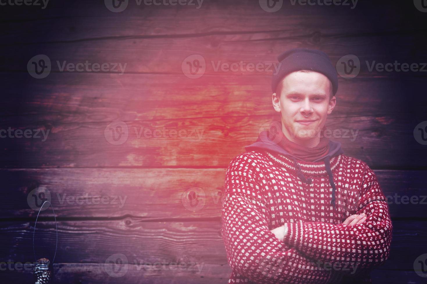 young hipster in front of wooden house photo