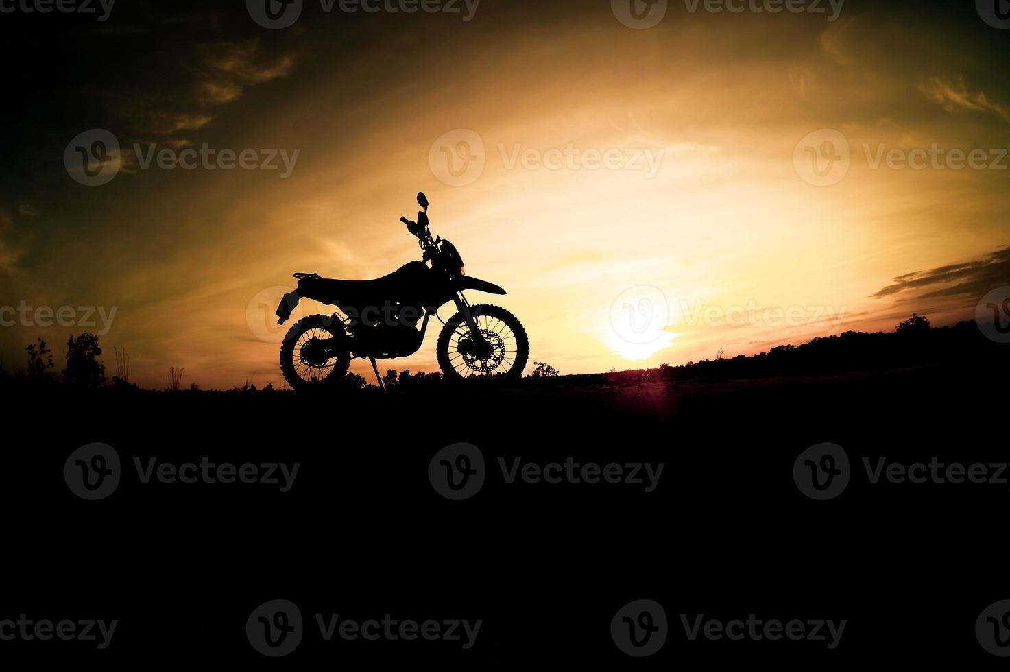 parque de silueta de motocross de motocicleta turística en la montaña por la noche. concepto de viaje de aventura foto