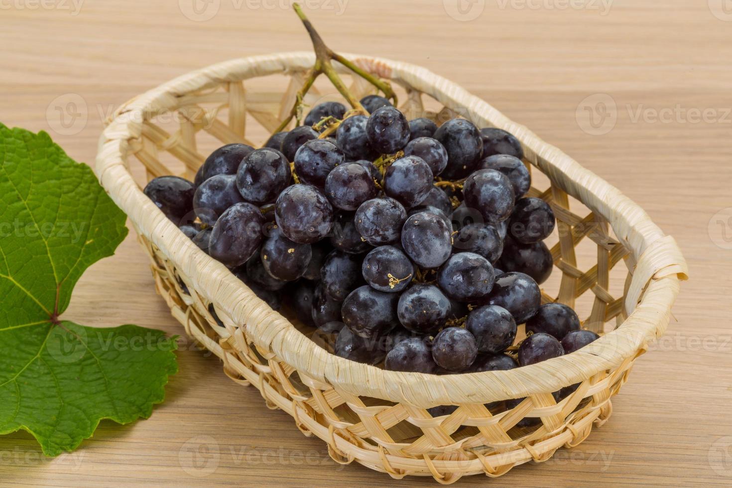 Grape in a basket on wooden background photo