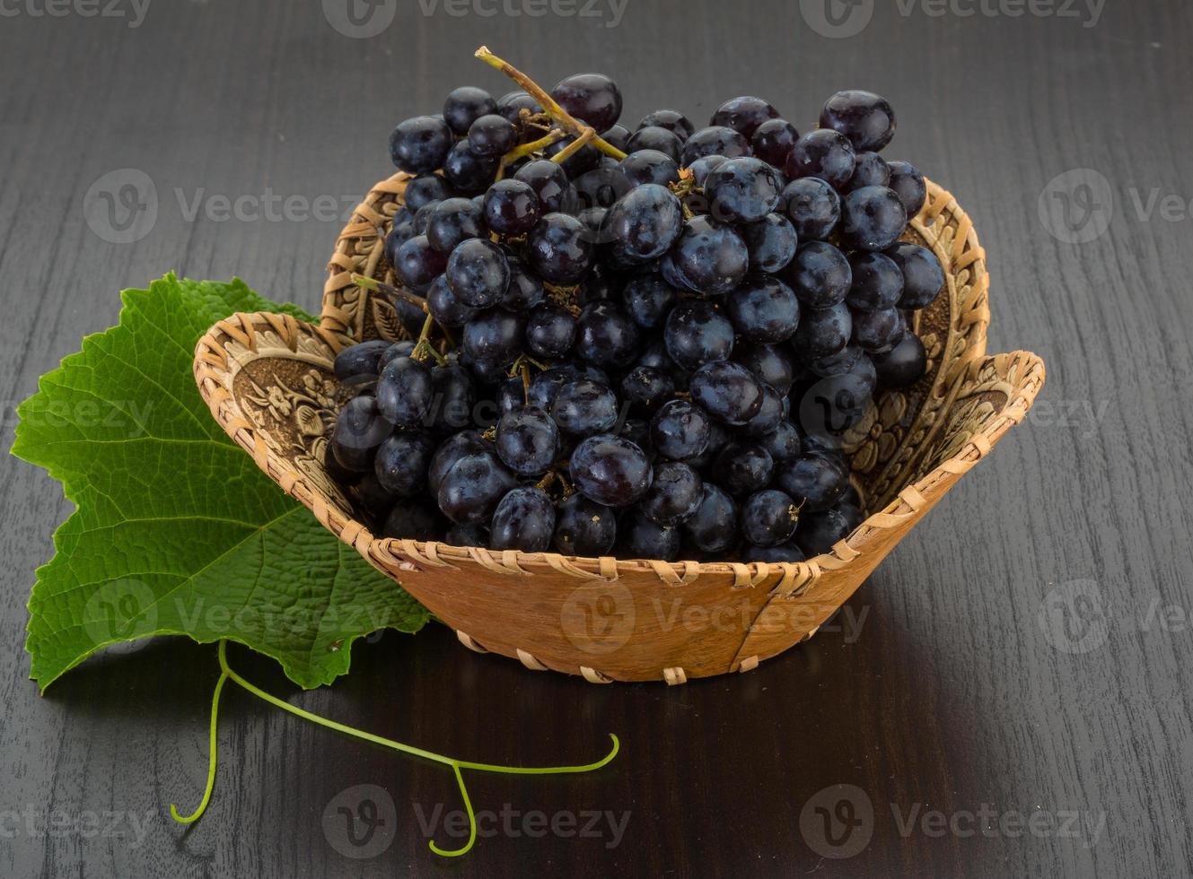 Grape in a basket on wooden background photo
