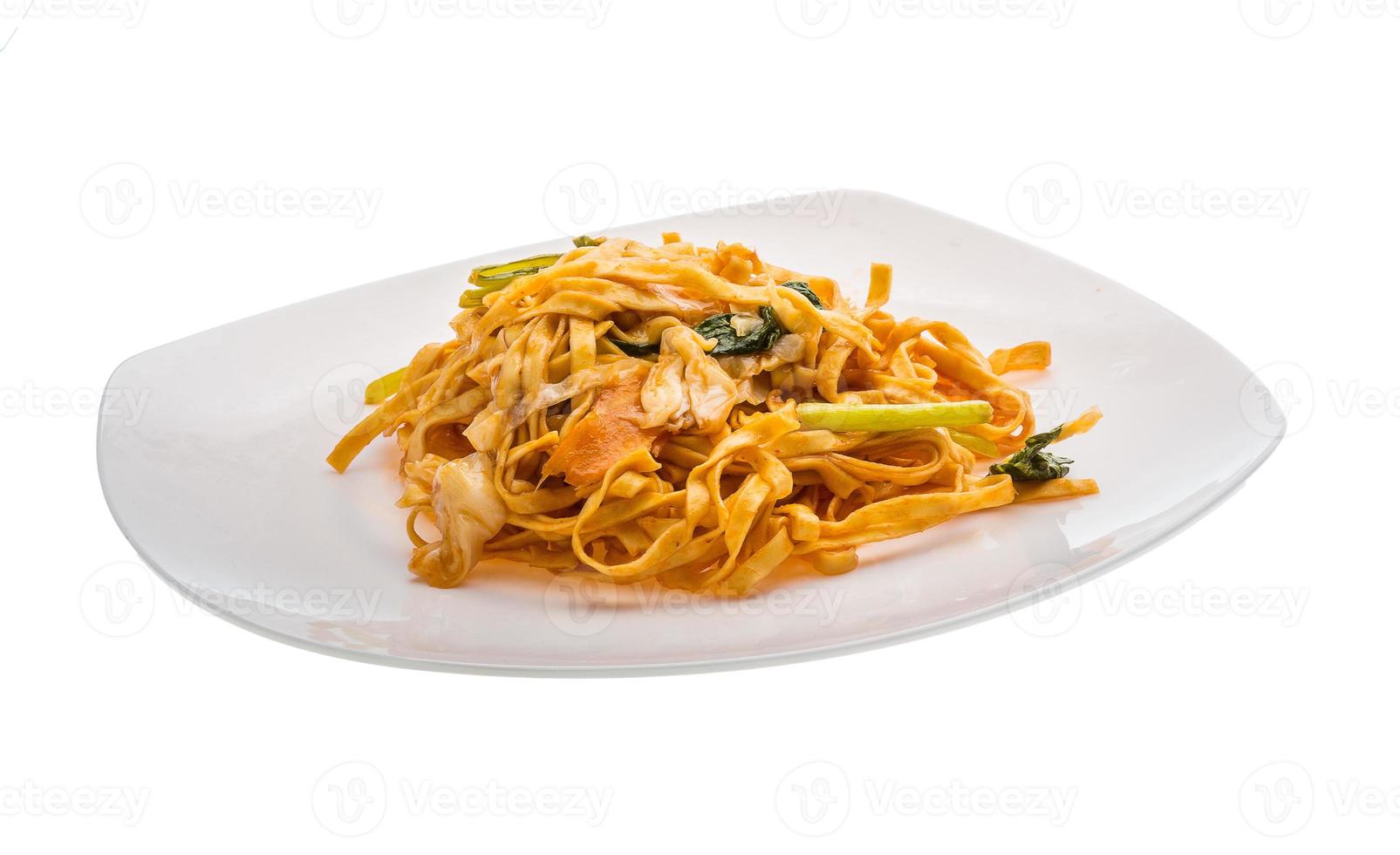 fideos fritos con verduras en el plato y fondo blanco foto