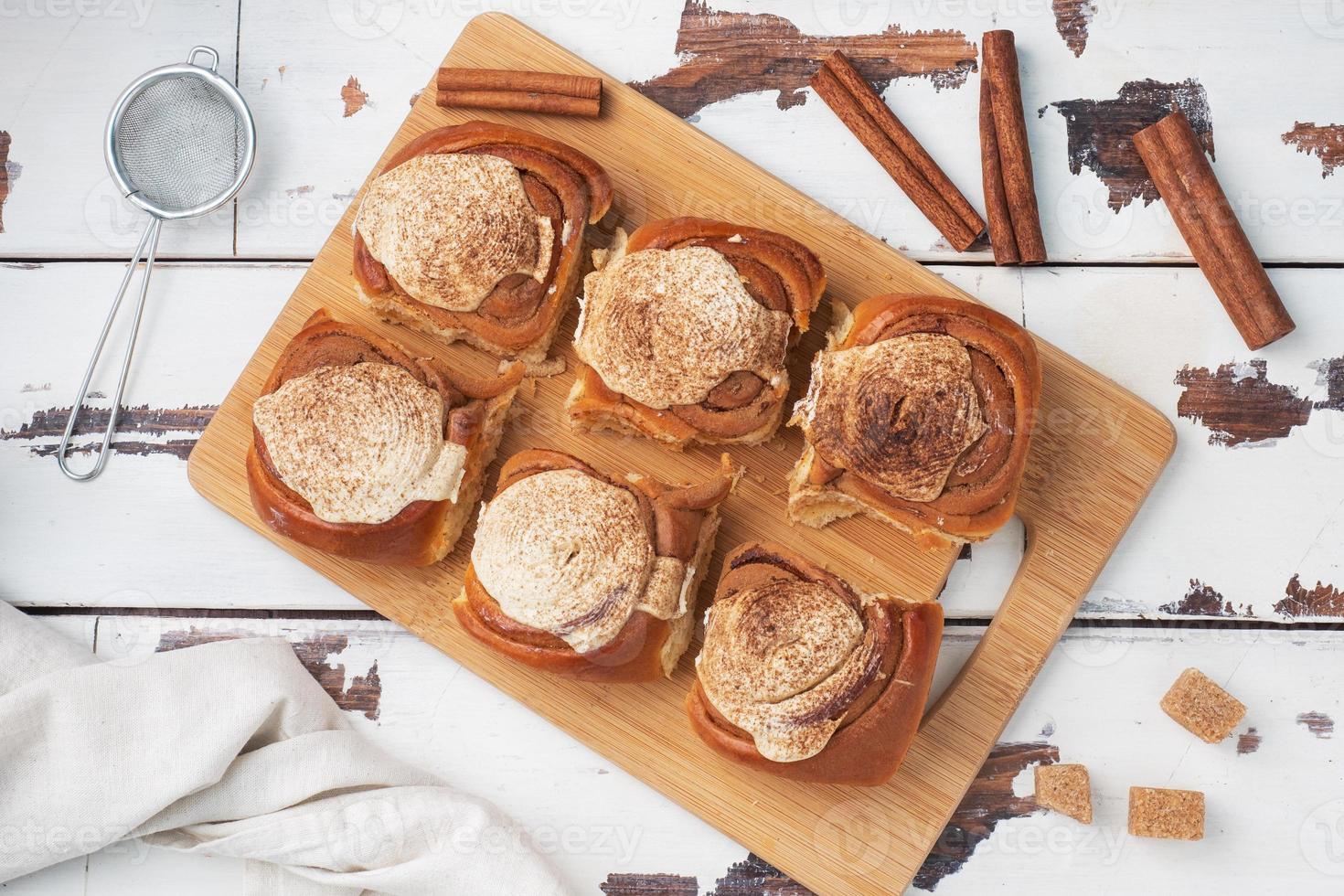 Kanelbulle Cinnamon buns with buttercream on a rustic wooden table. Homemade fresh pastries. top view, copy space. photo