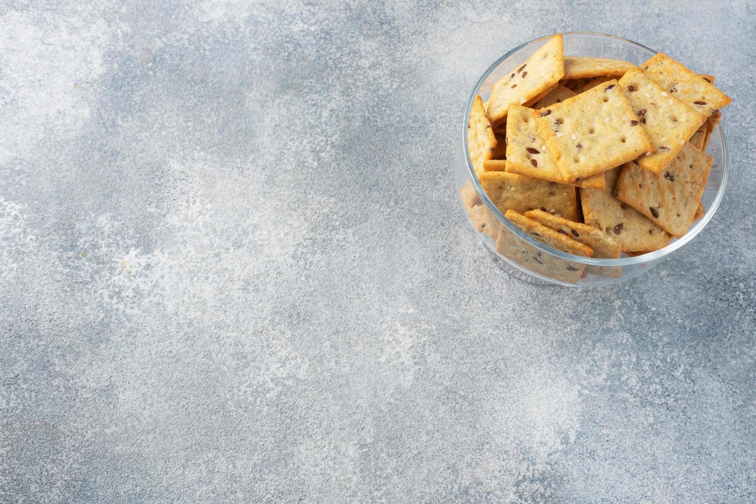 Delicious healthy cookies crackers with flax seeds and sesame seeds on a plate. Background of a healthy snack food, grey concrete table, Copy space photo