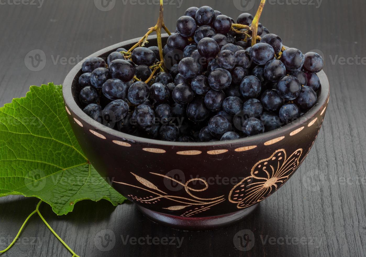 Grape in a bowl on wooden background photo