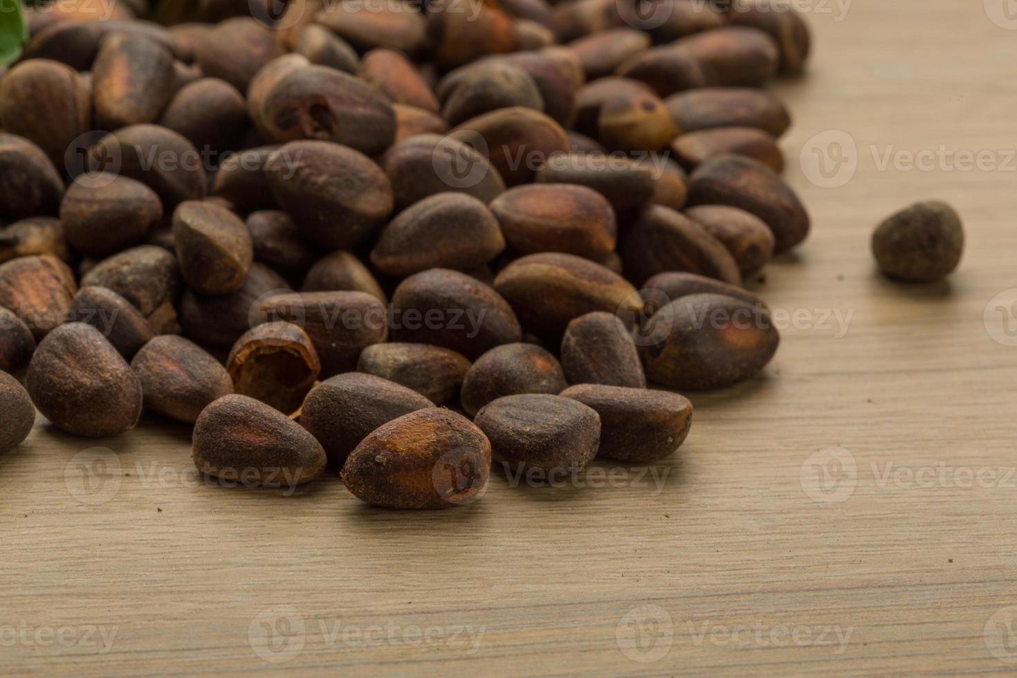 Cedar nuts on wooden background photo