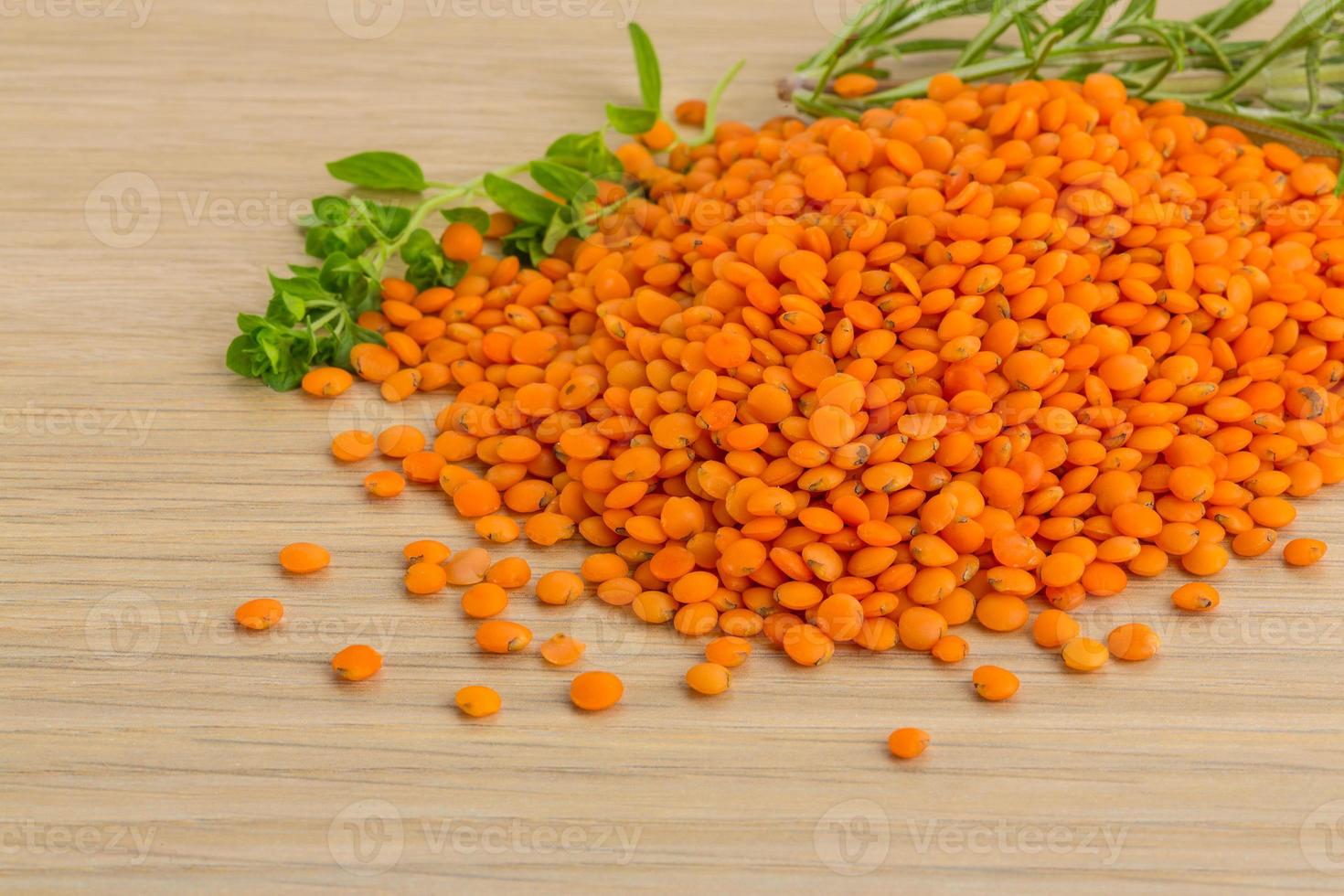 Raw red lentils on wooden background photo