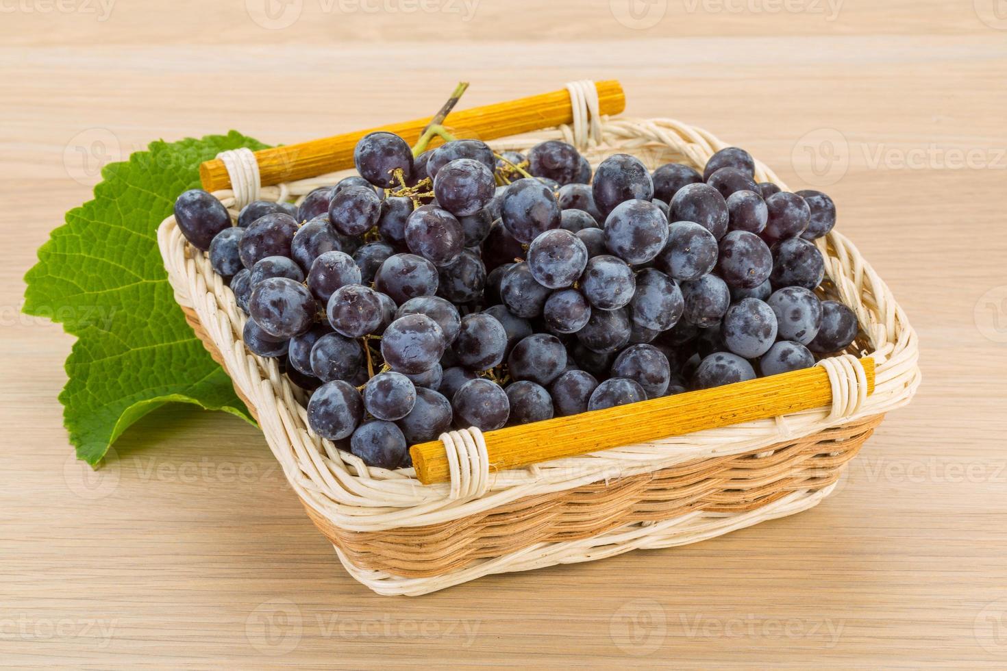 Grape in a basket on wooden background photo