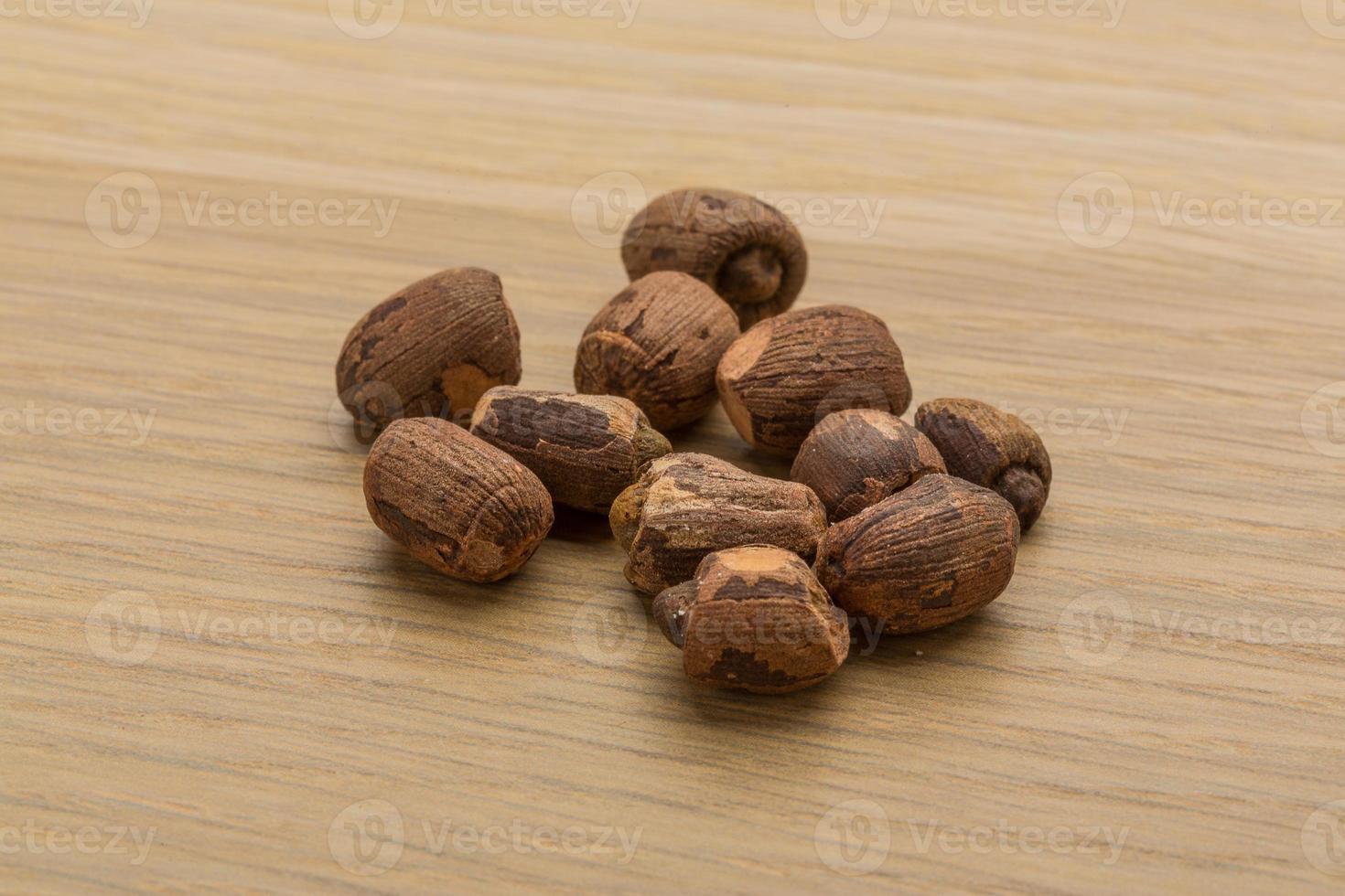 Small nutmeg on wooden background photo