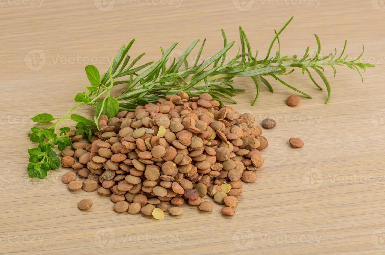 Raw lentils on wooden background photo