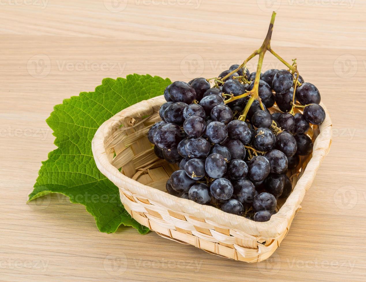Grape in a basket on wooden background photo