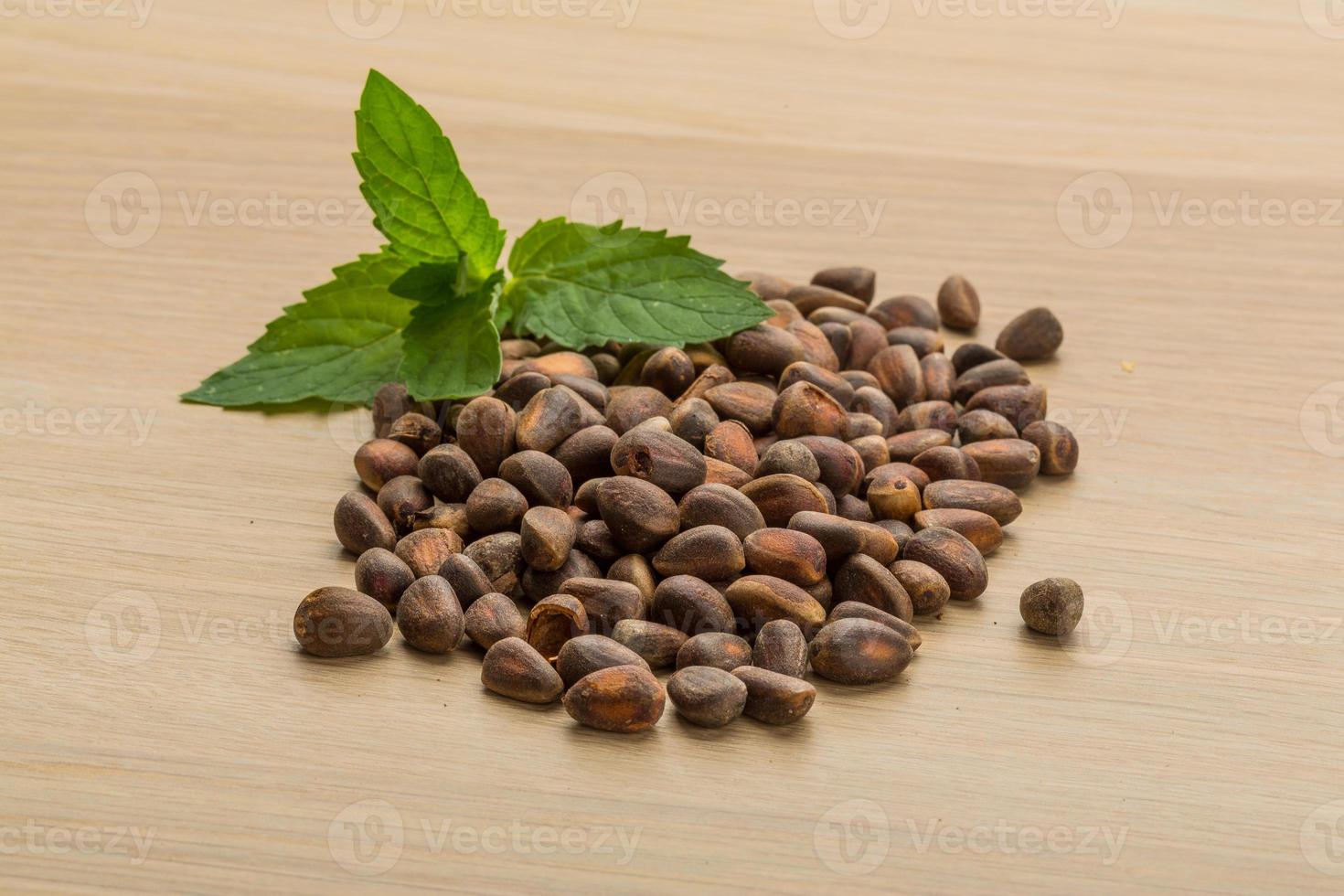 Cedar nuts on wooden background photo