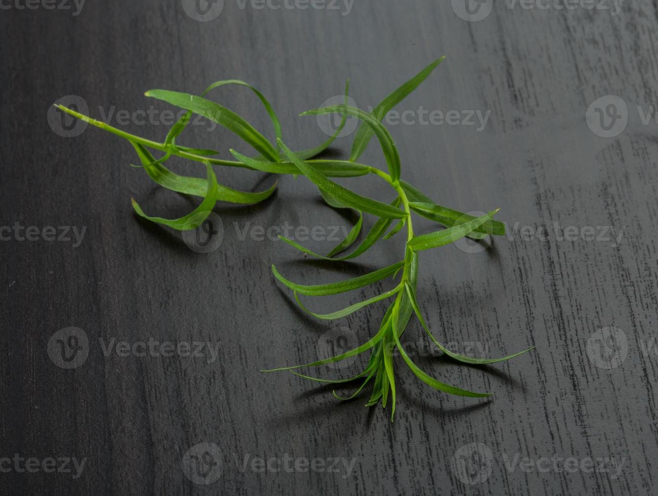 Tarragon leaves on wooden background photo