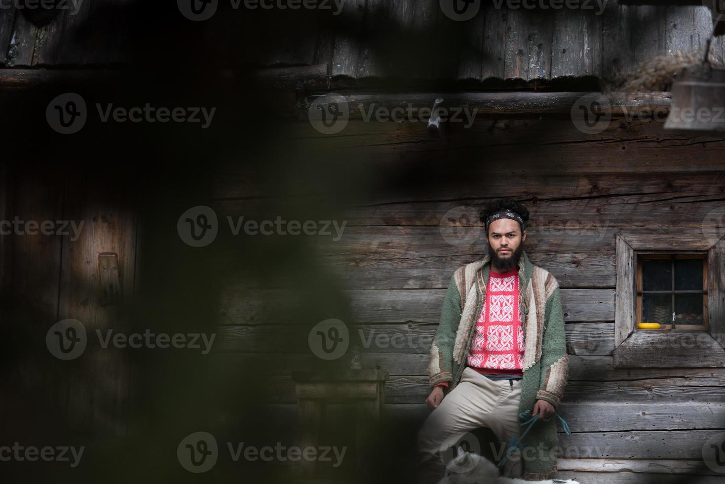 hipster with dog in front of wooden house photo