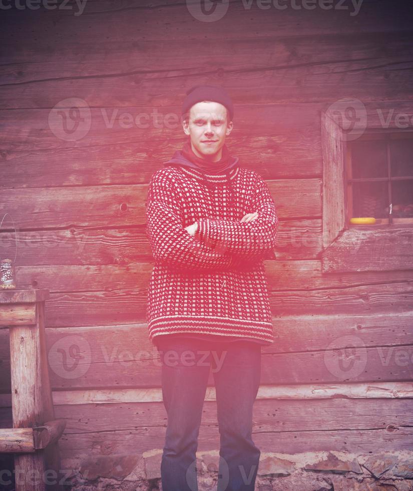young hipster in front of wooden house photo