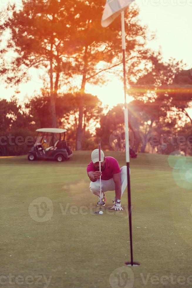 jugador de golf apuntando tiro perfecto en la hermosa puesta de sol foto