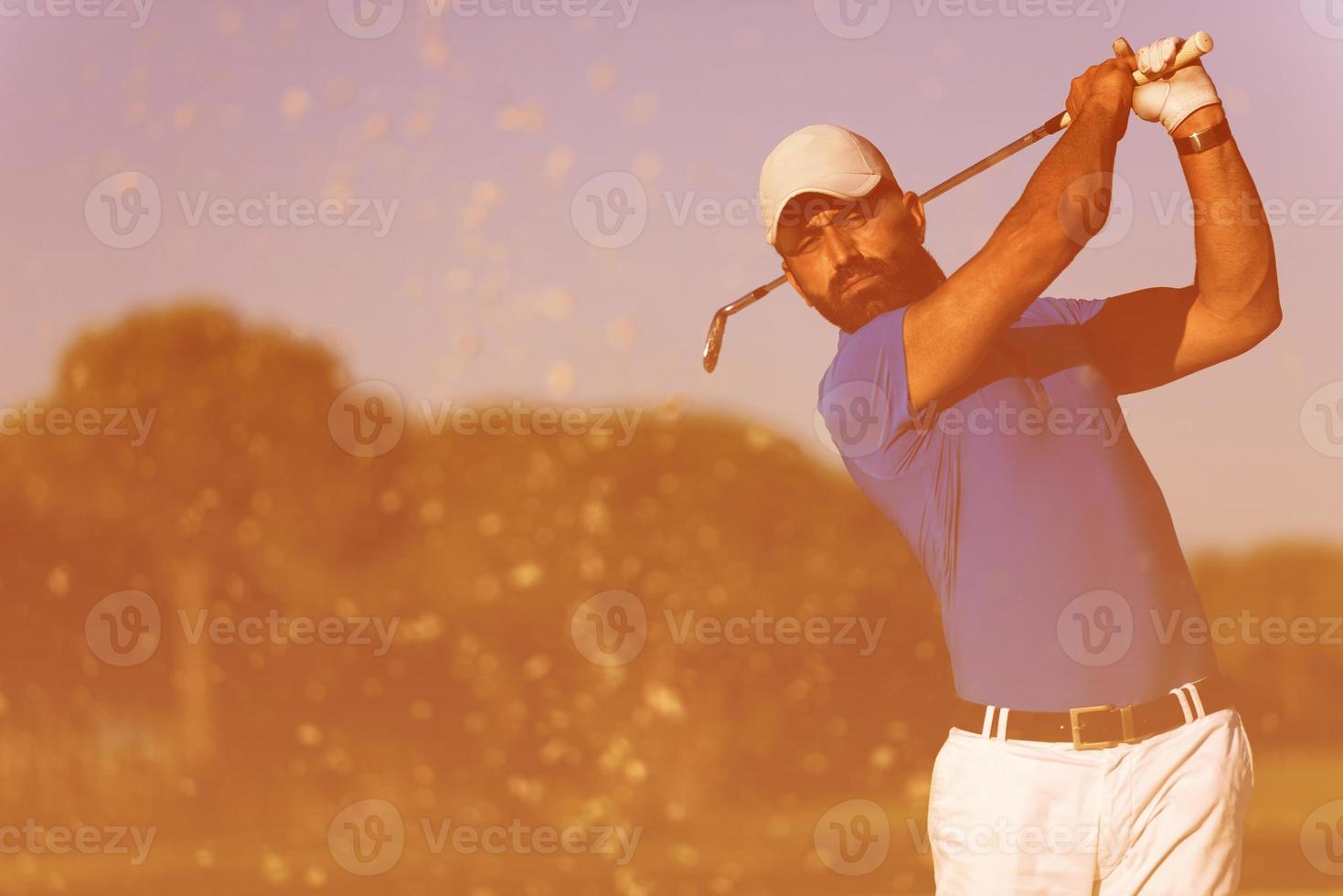 pro golfer hitting a sand bunker shot photo