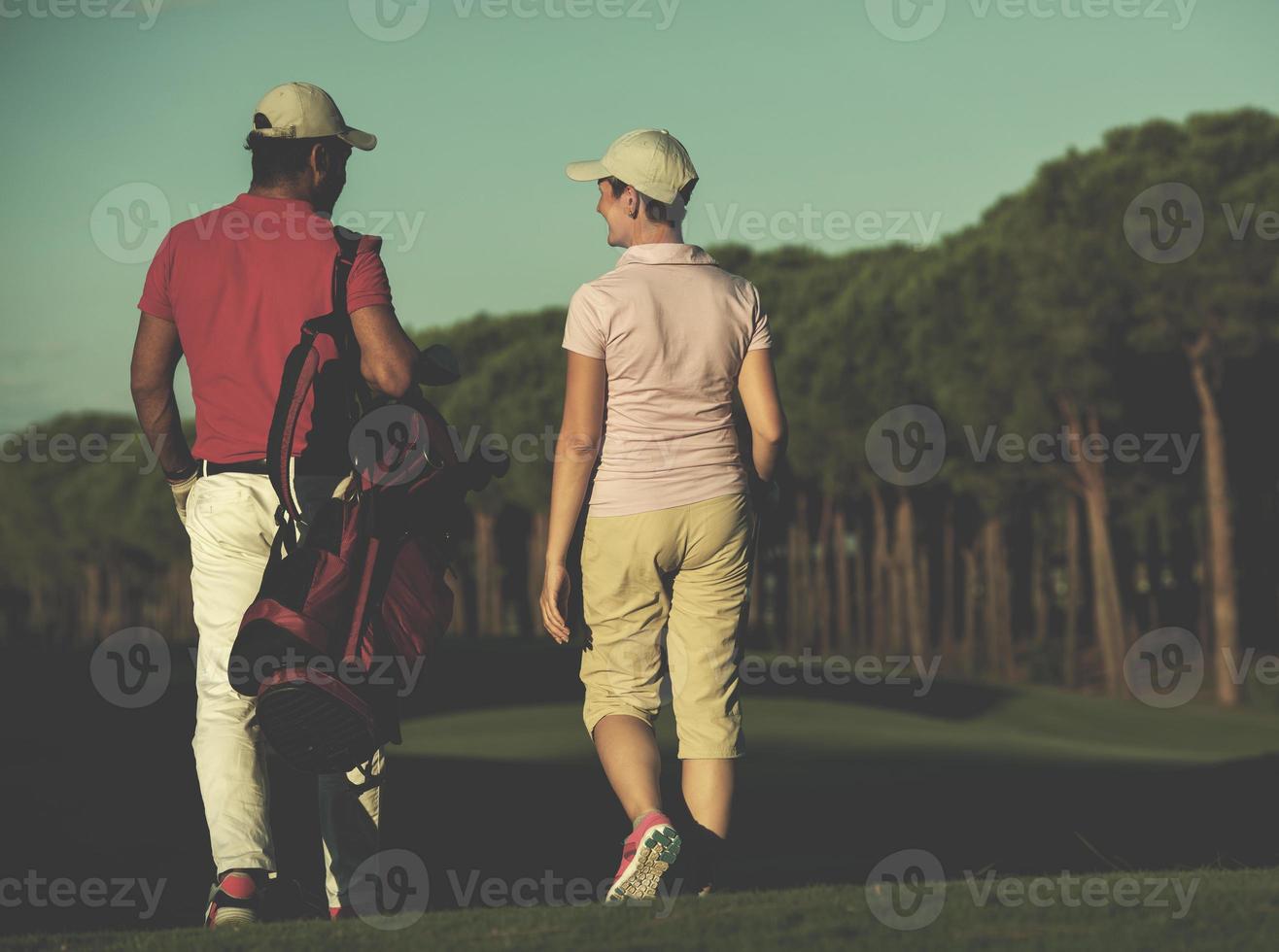 pareja caminando en campo de golf foto