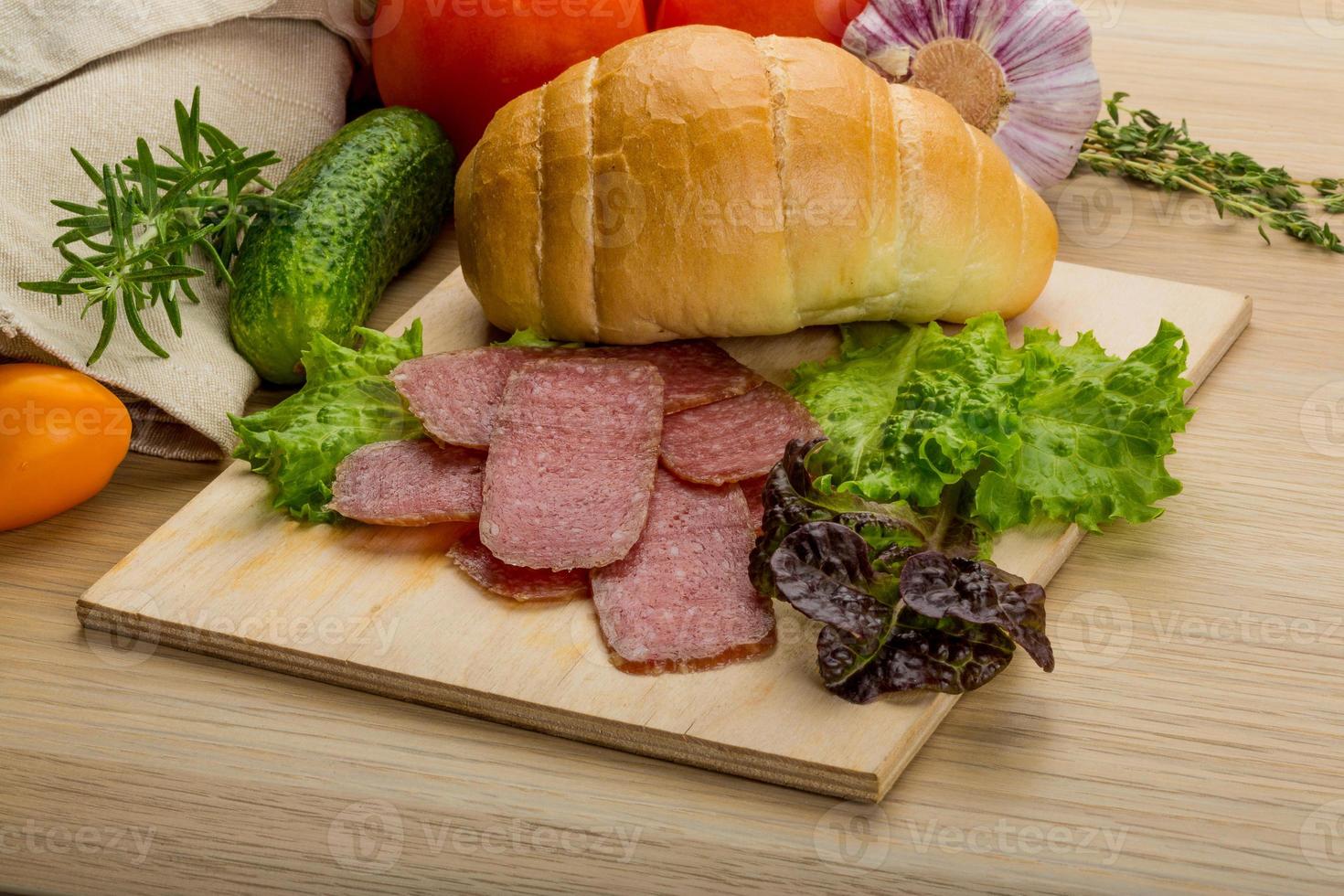 salchichas de salami en placa de madera foto