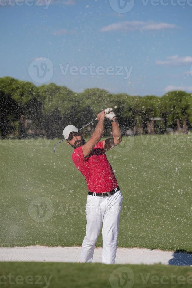 golfer hitting a sand bunker shot photo