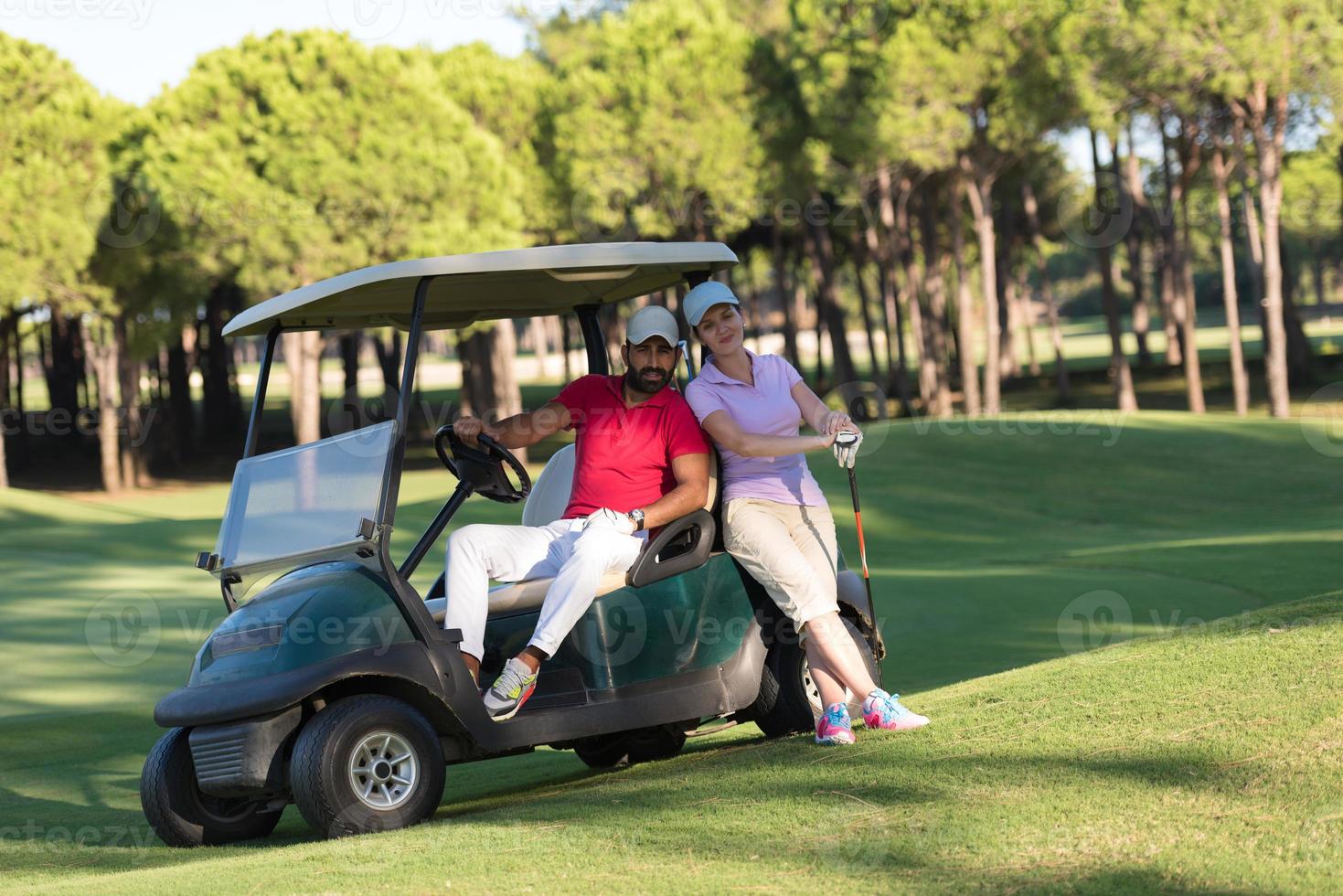 couple in buggy on golf course photo