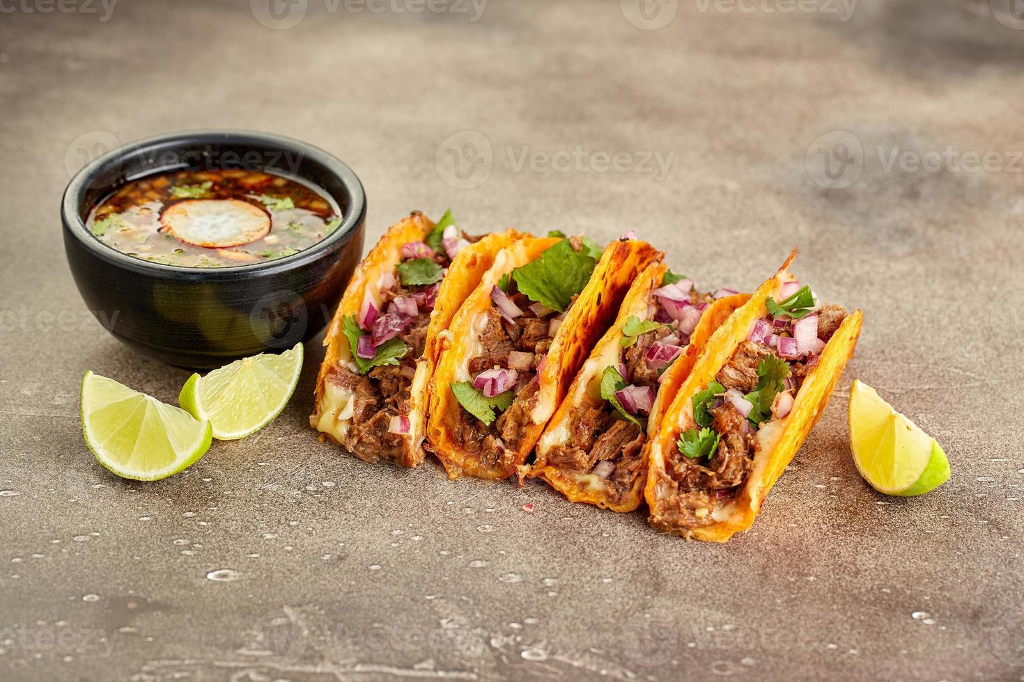 sopa tradicional mexicana de birria y cuatro tacos con ternera guisada foto