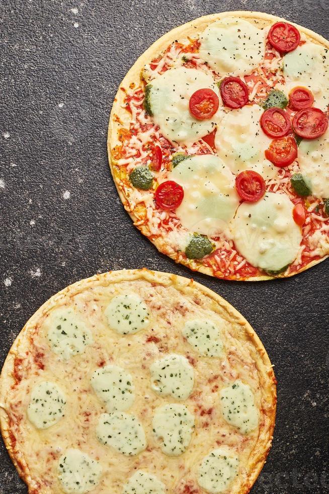 comida rápida, pizza congelada al horno cuatro quesos y pizza con queso mozzarella, tomates y pesto. listo para comer foto